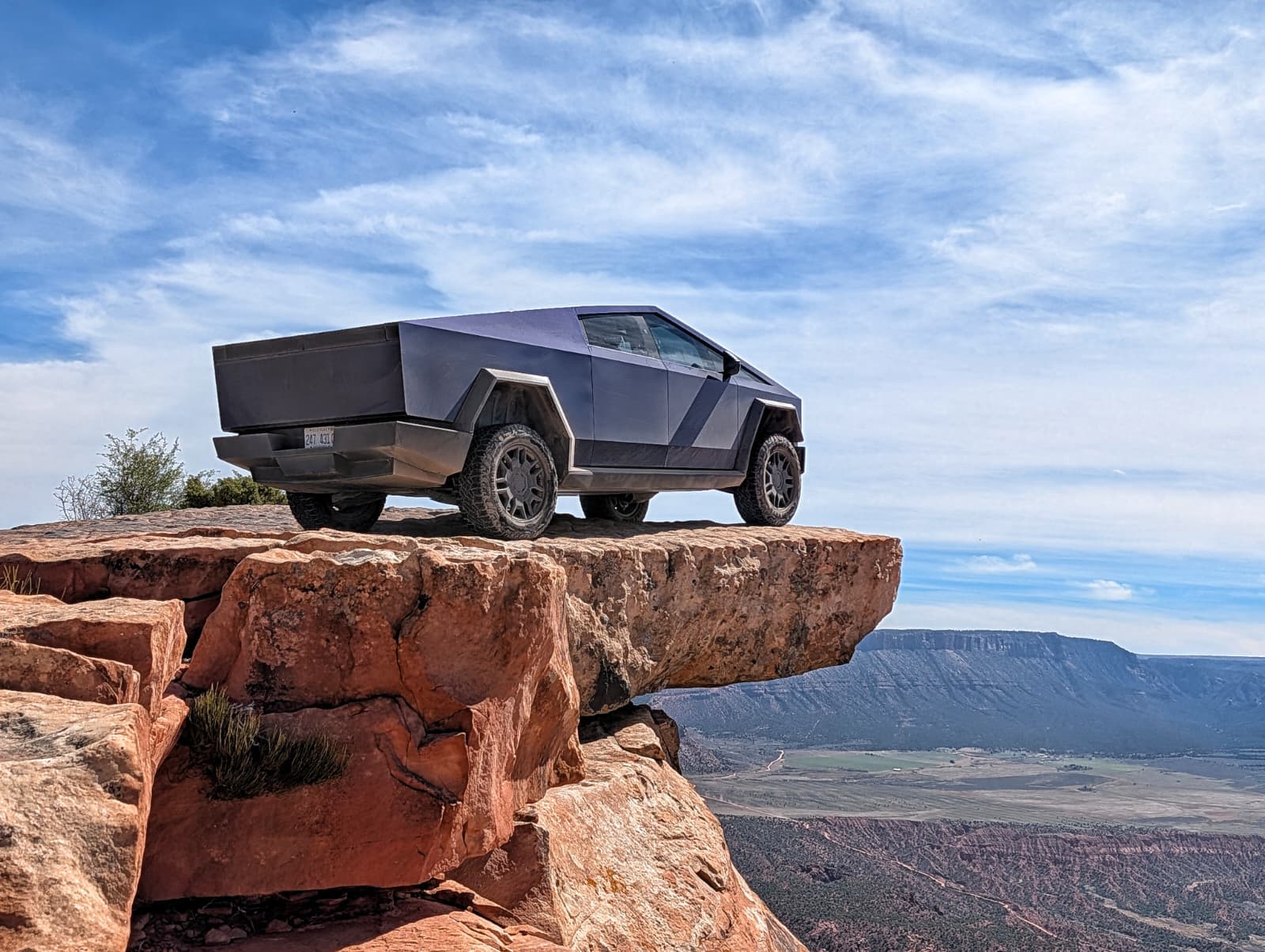 Cybertruck on red rock cliff edge overlooking canyon